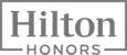 The image shows the logo of Hilton Honors, the loyalty program by Hilton hotels, with "Hilton" and "Honors" written in bold letters within a rectangular frame.