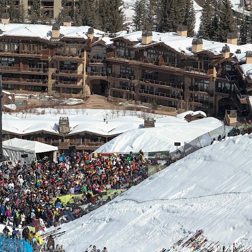 A large crowd gathers at a snowy ski event with a backdrop of a luxurious lodge, and a US Open banner is prominently displayed in the scene.