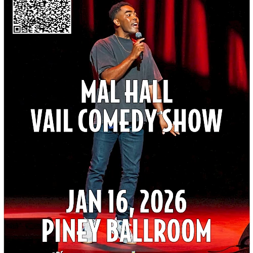 A stand-up comedian performs on stage at the Mal Hall Vail Comedy Show, January 16, 2026, Piney Ballroom, with a QR code and bright red curtains.